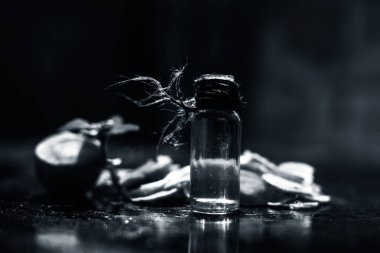 Siyah masa yüzeyinde kesilmiş taze havuçlar, bulanık arka plan ve küçük şeffaf cam bir şişede çıkarılmış gerekli yağlar. Yatay çekim.