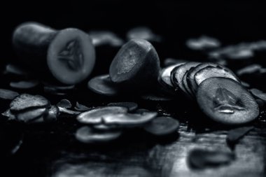 Siyah ahşap bir yüzey üzerinde havuç maskesi. Biraz taze sıkılmış havuç suyu, salatalık ezmesi ve ekşi krema. Sivilce ve deri renginin tedavisi için cam bir kaseye iyi karıştırılmış..