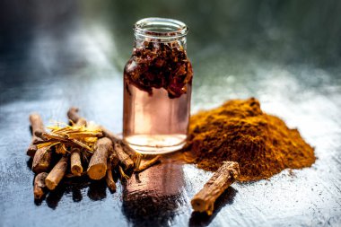 Hızlı iyileşen yara macunu doğal ayurvedik bitkilerden oluşur. Revand chini iyi karıştırılmış gül suyu ve bal. Ahşap bir yüzey üzerinde revand chini kökleri, toz, gül suyu ve bal..;