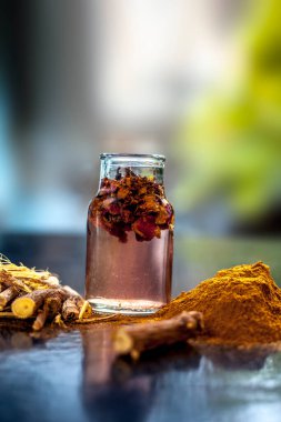 Hızlı iyileşen yara macunu doğal ayurvedik bitkilerden oluşur. Revand chini iyi karıştırılmış gül suyu ve bal. Ahşap bir yüzey üzerinde revand chini kökleri, toz, gül suyu ve bal..;
