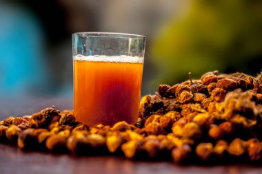 Kahverengi yüzeyde taze çiğ sabun ve çözeltisi ya da bir bardaktaki sıvıyla yakın çekim yap..