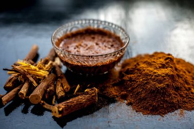 Taze ham revand chini köklerini yakın plan çekin ve cam bir kaseye yapıştırın. Tahta siyah bir yüzey üzerinde biraz ham toz ile birlikte..