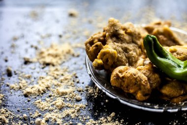 Meşhur Aloo pakora / aloo bhajia yeşil biberli cam bir tabakta ve şeffaf cam bir tabakta biraz nohut yayılmış. Yatay çekim.