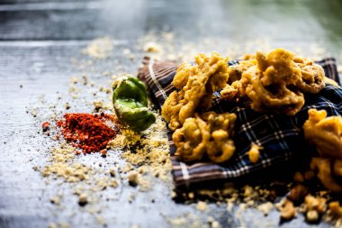 Ünlü kanda bhaji ya da kanda bhajiya ya da kanda pakora siyah bir yüzey üzerinde bir kabın içinde nohut unu, baharat ve diğer tüm malzemelerle birlikte. Yatay çekim.