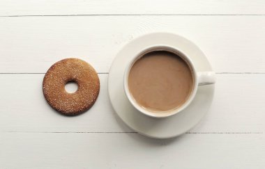 Ahşap arka planda bir fincan kahve. Beyaz arka plan ve sütlü kahve.