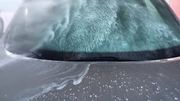 视频显示一个非接触式洗车 强大的水压与泡沫的玻璃和引擎盖 流下来 — 图库视频影像