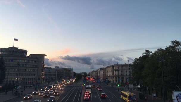 Russia, St. Petersburg, August 22, 2018. View from the height of the road with cars, evening, semicircular house with the Russian flag, develops, old Fund house, beautiful sunset, sky, headlights. — Stock Footage Russia Petersburg August 2018 View Height Road Cars Evening Semicircular Royalty Free Stock Footage