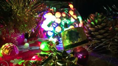 kompozisyon çeşitli Noel süsleri, yanıp sönen çelenk, bekle Noel ağacı, farklı boyutlarda koniler, yazıt mutlu yeni yıl ile altın bir şapka oyuncaklar
