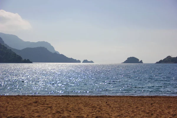 Вид Пляж Желтым Песком Море Сияют Лучи Солнца Горы Крыльях — стоковое фото