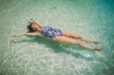 Kristal açık denizde su yüzeyinde yalan güzel kadın. Koh Phi Phi, Tayland