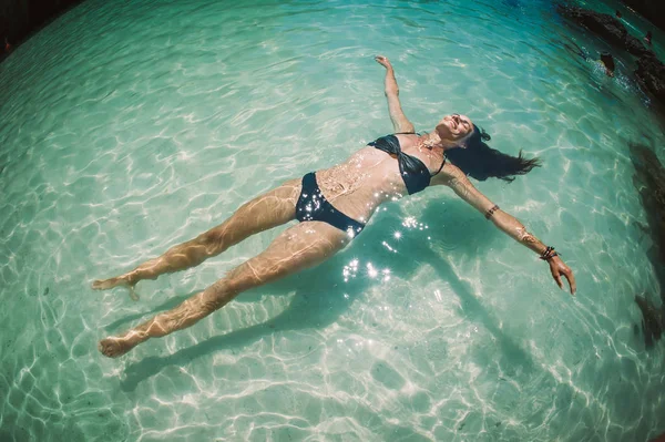Kristal açık denizde su yüzeyinde yalan güzel kadın. Koh Phi Phi, Tayland