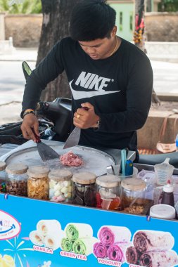 Phuket, Tayland - 11. Mart 2018. Kimliği belirsiz bir Asya satıcı geleneksel tatlı Caddesi üzerinde Tayland yemekleri hazırlar. Gün Editör atış