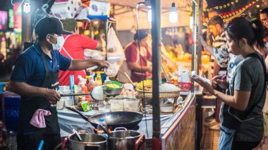 Phuket, Tayland - 10. Mart 2018. Kimliği belirsiz bir Asya satıcı gıda sokakta hazırlar. Pad Tay dili Gün Editör atış