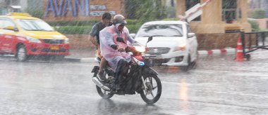 Pattaya Tayland - Mayıs 2018 yaklaşık. Motosiklet sürücüsü ağır tropik fırtına yağmur sırasında ıslak Tay sokaklarda. Muson sezonu. Gün Editör atış