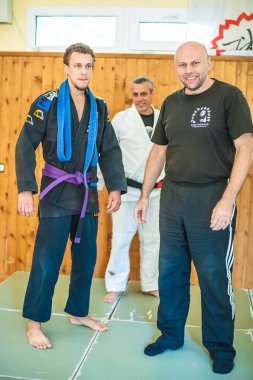 BELGRADE, SERBIA - 12. OCTOBER 2018. Student is promoted and gets BJJ Brazilian Jiu-Jitsu Purple Belt on the AVI NARDIA KAPAP SELF DEFENSE SEMINAR clipart
