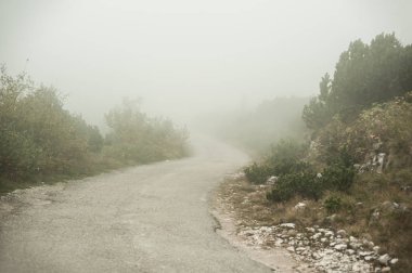 Büyülü atmosfer ve yolda gizemli sis ile manzara. Durmitor, Karadağ