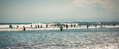 Bali, Endonezya - 28. Nisan 2018. Plaj bazı dalgalar yakalamak hazırlanıyor sörfçü tam. Gün Editör atış