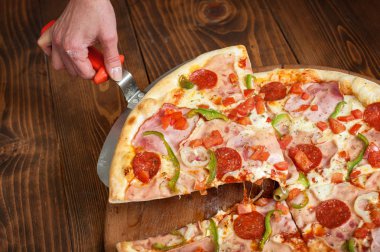 Dilim pizza sucuk olarak skapula ahşap masa üzerinde. Lezzetli lokanta İtalyanca geleneksel