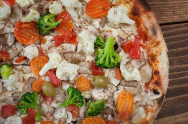 Ahşap arka plan, üstten görünüm üzerinde taze İtalyan pizza vegetariana. Lezzetli İtalyan Lokanta