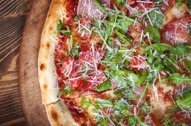 Ahşap arka plan, üstten görünüm üzerinde taze İtalyan pizza rucola. Lezzetli İtalyan Lokanta