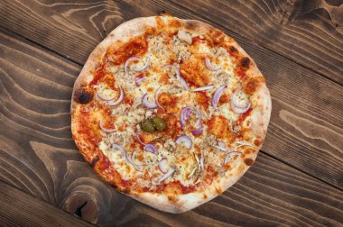 Ton balığı ve kırmızı soğan pizza ahşap arka plan, üstten görünüm üzerinde. Lezzetli İtalyan Lokanta
