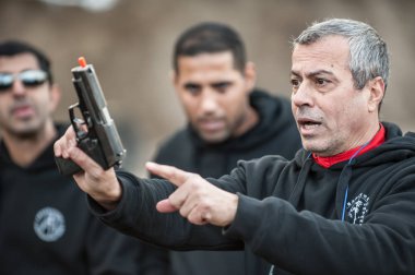 Pozarevac, Sırbistan - Aralık 21-24, 2018: Kapap eğitmen avı Nardia atış talimine Grom, öğrencilerin büyük bir grup öğretir nasıl güvenli bir şekilde silah Kapap temel ateşli silah emniyet ve silah kullanmak konulu seminer kullanmak