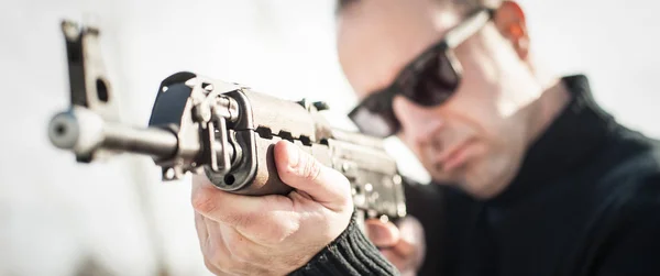 Front view gun point of riffle machine gun. Firearm shooting and weapons training. Winter snow background on outdoor shooting range