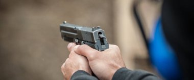 Tetikçi holding silah görünümünü el detay ve silah, yakın çekim. Çekim aralığı