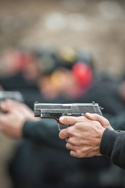 Yakın çekim ayrıntı görünümü tetikçi pratik tabanca atış talimine kişilerin satır grubundaki hedefte çekim