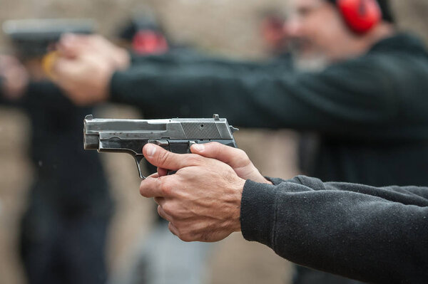 Группа гражданских практикует стрельбу по мишеням на открытой стрельбище. Обучение гражданской команды вооружению
