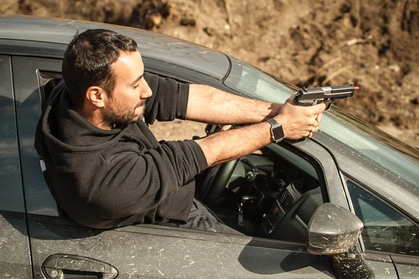 Police agent and bodyguard training action gun shooting from car. Special agent team weapons training and course on outdoor shooting range