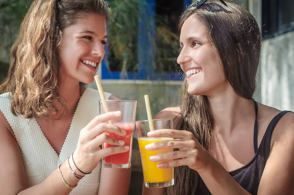 Két barátnő, ivás gyümölcs koktél, egy trópusi tengerparton — Stock Fotó