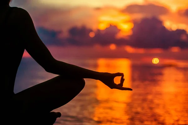 Жінка медитує, розслабляється в позі йоги на заході сонця, дзен-медіація — стокове фото