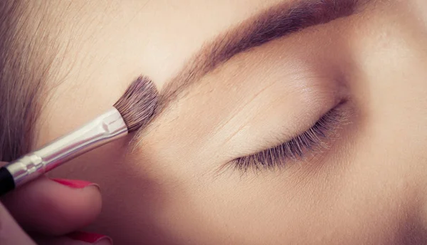 Artista de maquillaje profesional mejora las cejas en la f femenina — Foto de Stock