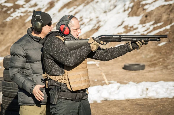 Istruttore sul poligono di tiro insegna allo studente a sparare con il fucile — Foto Stock