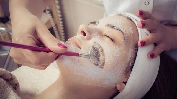 Kozmetikus alkalmazása arc szépség maszk nő a Spa szalon — Stock Fotó