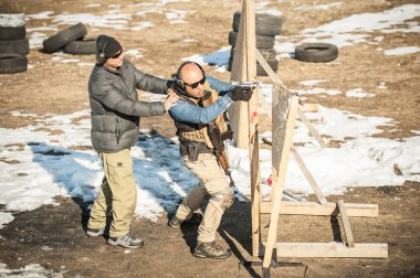 Eğitmen öğrenci taktik silah kapak veya barikat arkasında çekim öğretir