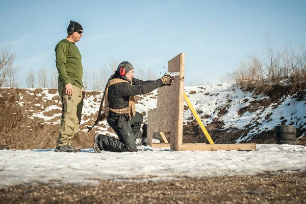 Instructor teaches student tactical gun shooting behind cover or barricade — Stock Photo, Image