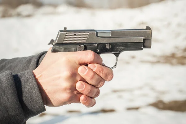 Close-up detail view of shooter hands holding gun and shooting — Stock Photo, Image