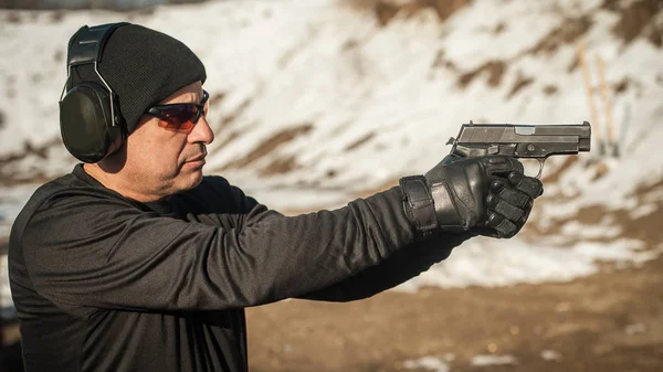 Un tiratore che tiene la pistola in mano e spara. Vista ravvicinata dei dettagli — Foto Stock