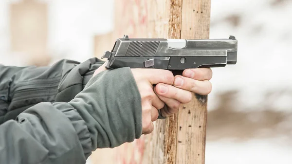 Vista de detalhe de close-up de mãos de atirador segurando arma e tiro — Fotografia de Stock