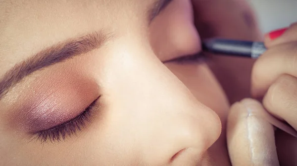 Professionel kunstner gør skønhed makeup til ung pige - Stock-foto