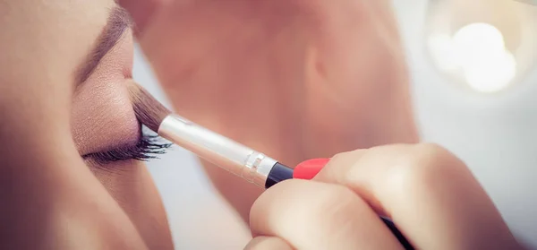 Artista profesional está haciendo maquillaje de belleza a la joven — Foto de Stock