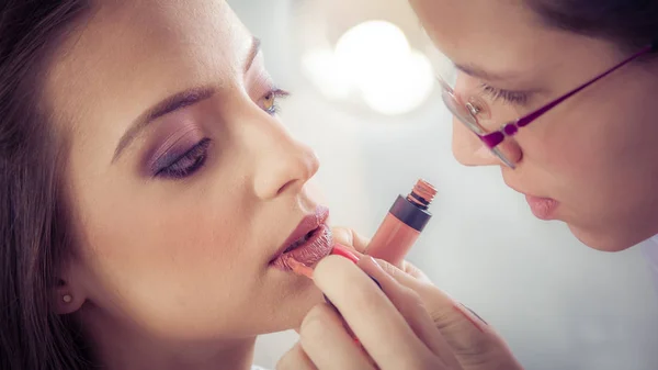 Artista profesional está haciendo maquillaje de belleza a la joven — Foto de Stock