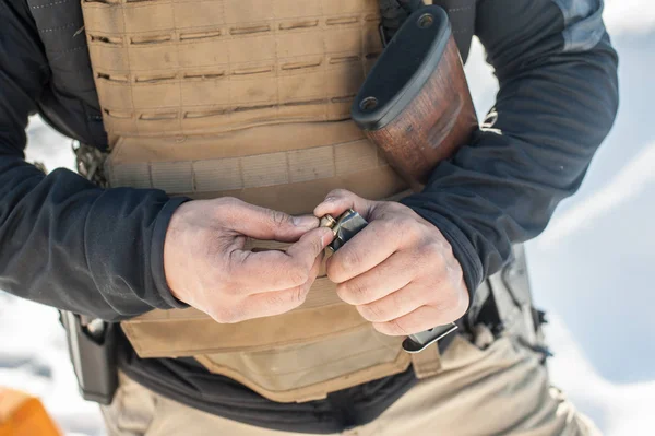 View of soldier hands load gun bullets into cartridge clip