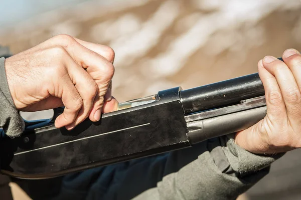 Soldier hands load shotgun bullets patrons into cartridge clip