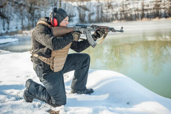 Army soldier in crouching position shooting from rifle machine gun — Stock Photo, Image