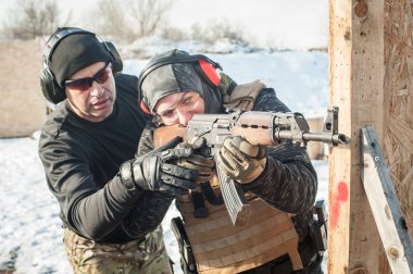 Eğitmen ve öğrenci tüfek leimeğitimi almışlar. Açık atış poligonu 
