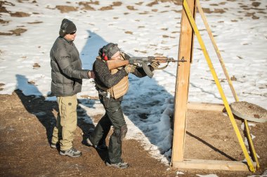 Eğitmen ve öğrenci tüfek leimeğitimi almışlar. Açık atış poligonu 