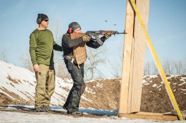 Eğitmen ve öğrenci tüfek leimeğitimi almışlar. Açık atış poligonu 
